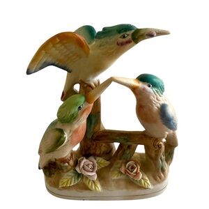 Vintage three kingfisher birds perched on a branch with roses